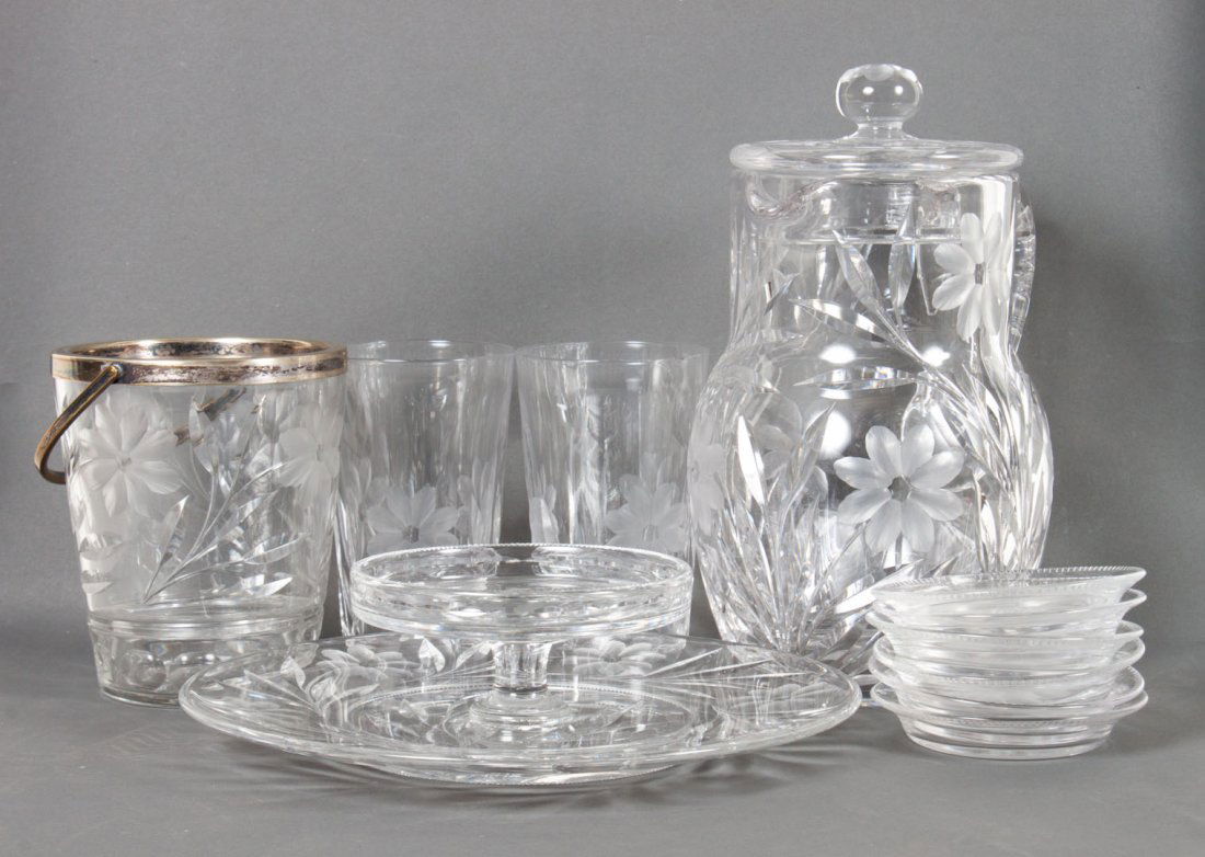 American cut glass cold drink/dessert set: early 20th century; possibly Pairpoint, each piece with cut glass peony decoration, 17 pieces, comprising: lidded pitcher, 7 water glasses, 7 coasters, ice bucket with silver-plated rim and handle, an