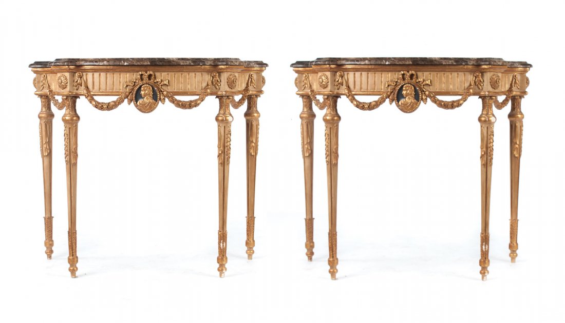 Pair of Louis XVI style giltwood console tables: carved giltwood console tables, brown and grey variegated marble tops with convex corners, 4 in. fluted aprons with carved swags and profile medallions, round-turned tapered legs with foliated feet, 3
