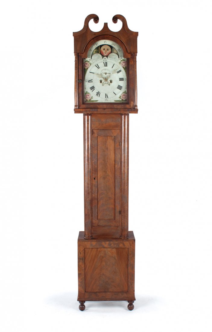 American Classical mahogany tall-case clock: Maryland, circa 1820; English works with painted face, moon phase, second sweep, calendar dial and Roman numerals, enclosed by bonnet with broken arch pediment and turned columnar supports, long door 
