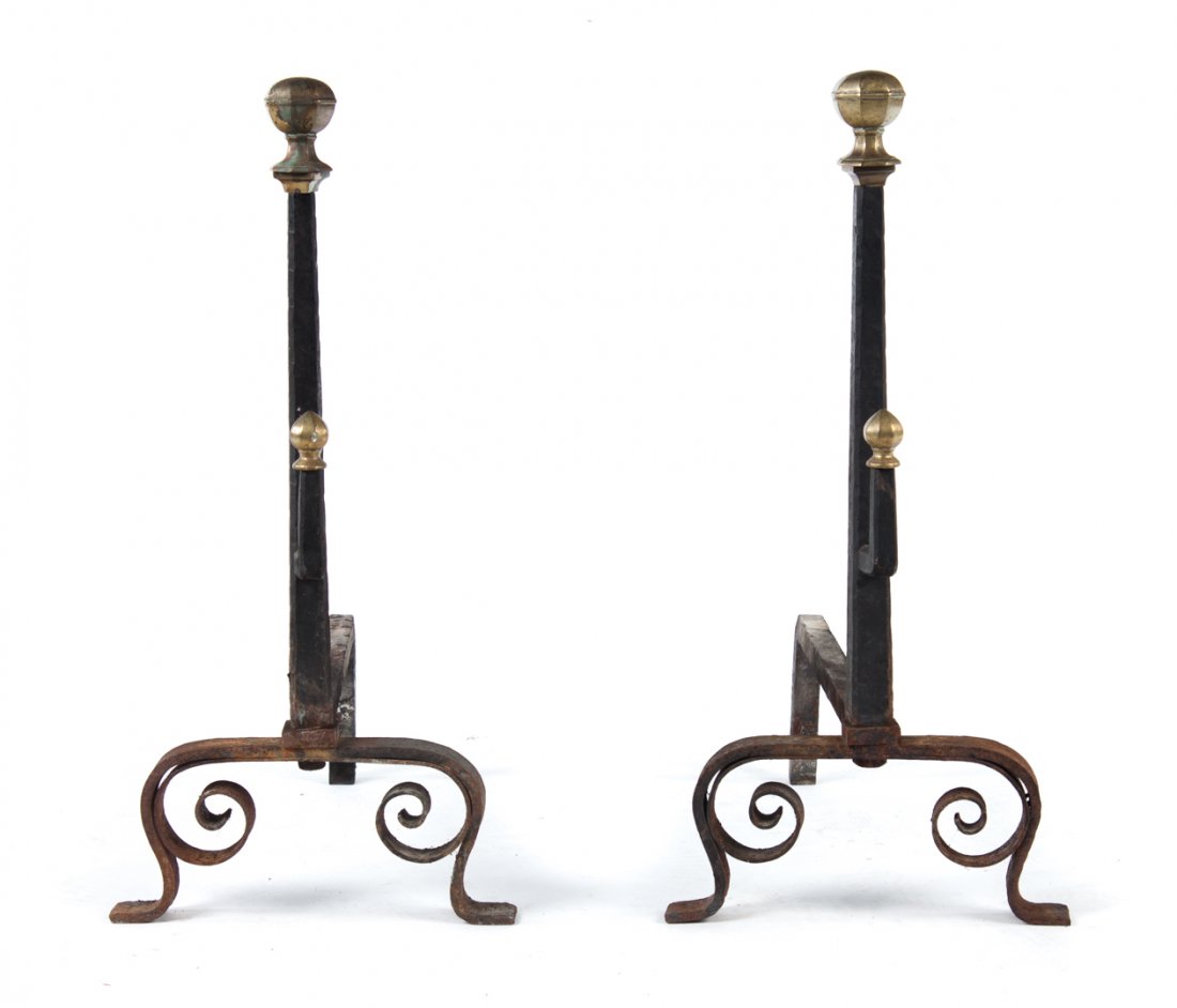 Tudor style wrought iron andirons: 20th century; octagonal cast brass finials on tapered wrought iron shafts with scroll legs and implement holders, 24 1/2 in. H.