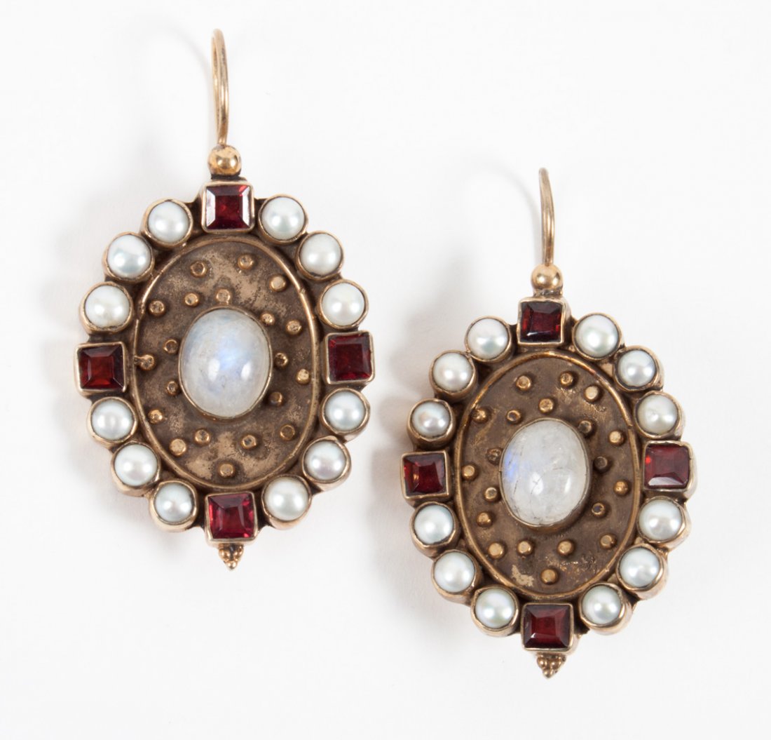 Pair of neoclassical style gold earrings: 19th century, each centering a moonstone cabochon on a studded gold field, framed with pearls and garnets, French wire backs, 1 1/2 in. H.; indistinct hallmarks verso, tests as 8K, 17.8 g. t.w.