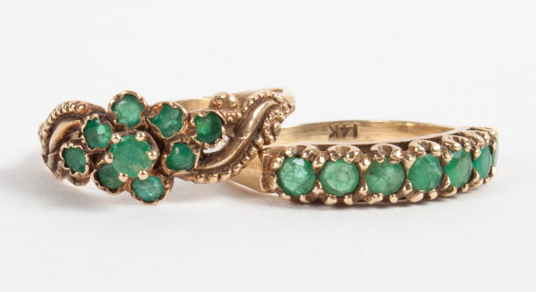 Two Edwardian period emerald rings: comprising an Art Nouveau style ring presenting 9 small emeralds in the shape of a flower, 14K, size 7 1/2; the second ring with 7 emeralds in a row with six-prong mounts, 14K, size 7; 4 grams t.w..