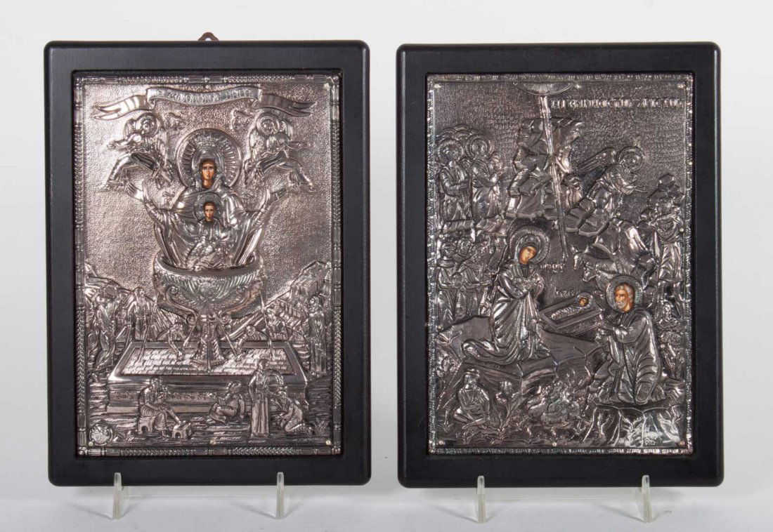 Pair of Greek icons with silver rizas: 20th century; each with silver relief decoration, with painted faces, set in laminated ebonized wood frame, with "950" mark, subjects include "The Nativity" and "Madonna Magnificant," frame size for b