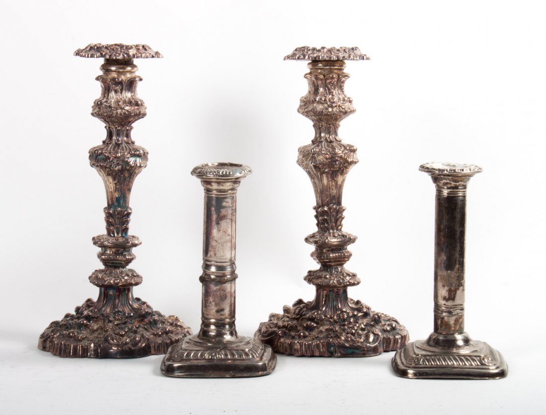 Pair of George IV weighted sterling candlesticks: dated 1824-25 and 1826-27, Sheffield maker's marks rubbed, heavily repoussed overall, 9 3/4 in. H., together with two other weighted silver candlesticks (damaged)