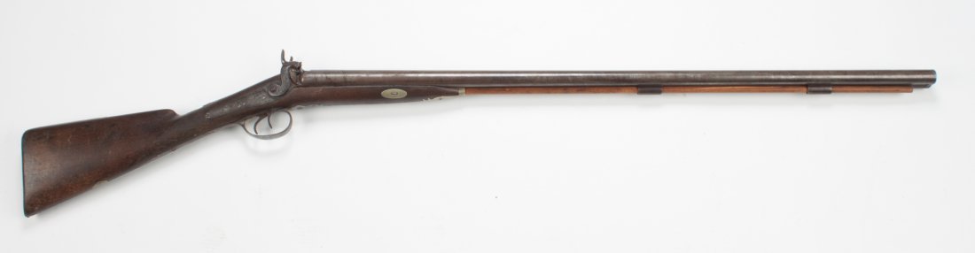 English percussion shotgun, Wm. Moore, London: third quarter-19th century; 12 gauge, double barrel, 34 in. L.; metal parts originally with bright and case-hardened finish, now lightly browned overall; checkered walnut stock; 49 in. L. overall; wit