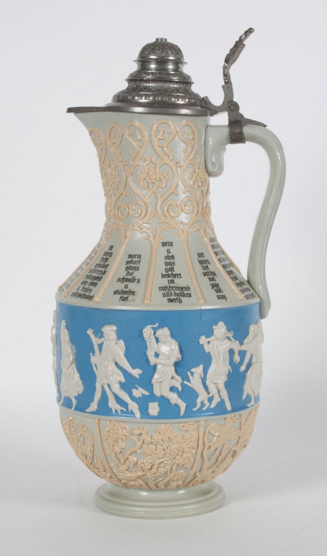 Mettlach salt glazed stoneware flagon: dated 1885; relief decoration of peasants, grapevines, and birds, with various mottoes, pewter mounts with engraved name and date, stamped mark, 14 1/2 in. H.