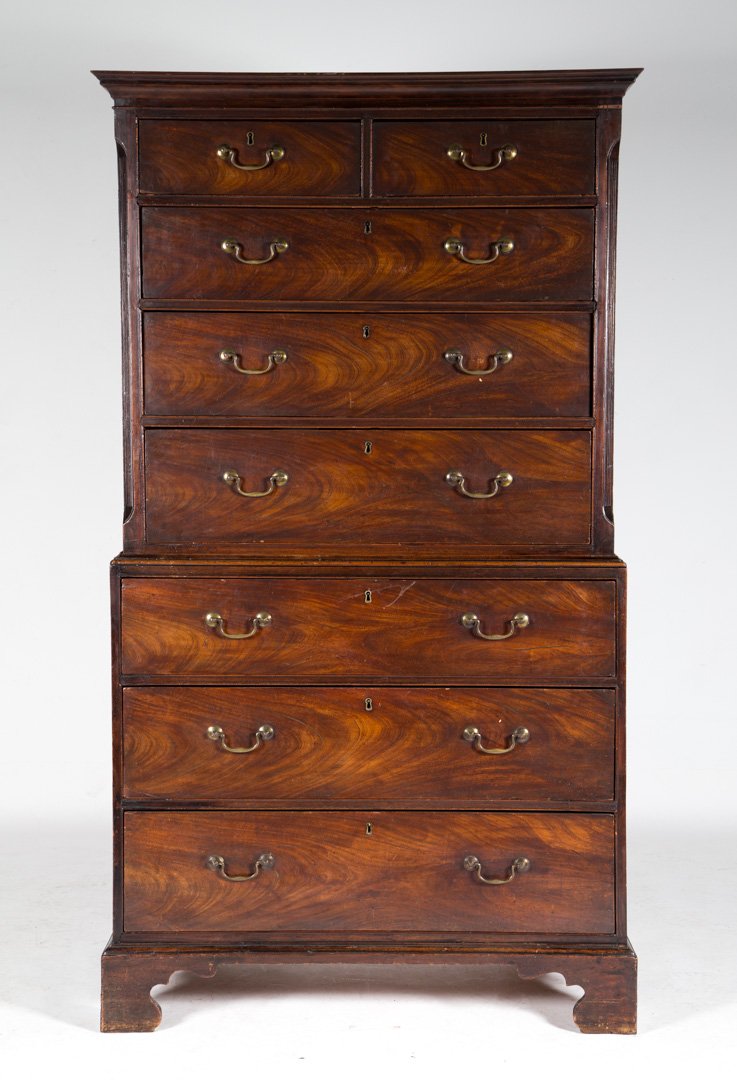 George III carved mahogany chest-on-chest: late 18th century; flat molded cornice, two short and three long drawers in upper case, reeded pilaster supports; lower case has three long drawers with straight bracket feet, rosette and bale brasses