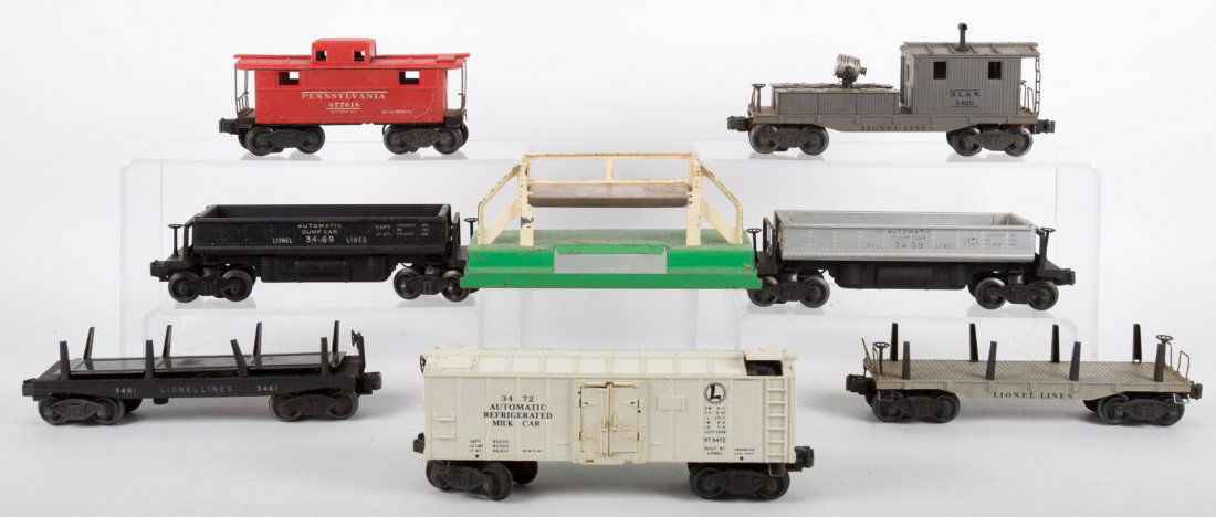 Lionel rolling stock, 8 pieces: Auto milk car, auto lumber car, dump car, caboose, auto dump car, flat car, searchlight wrecking car, all post-war, boxed