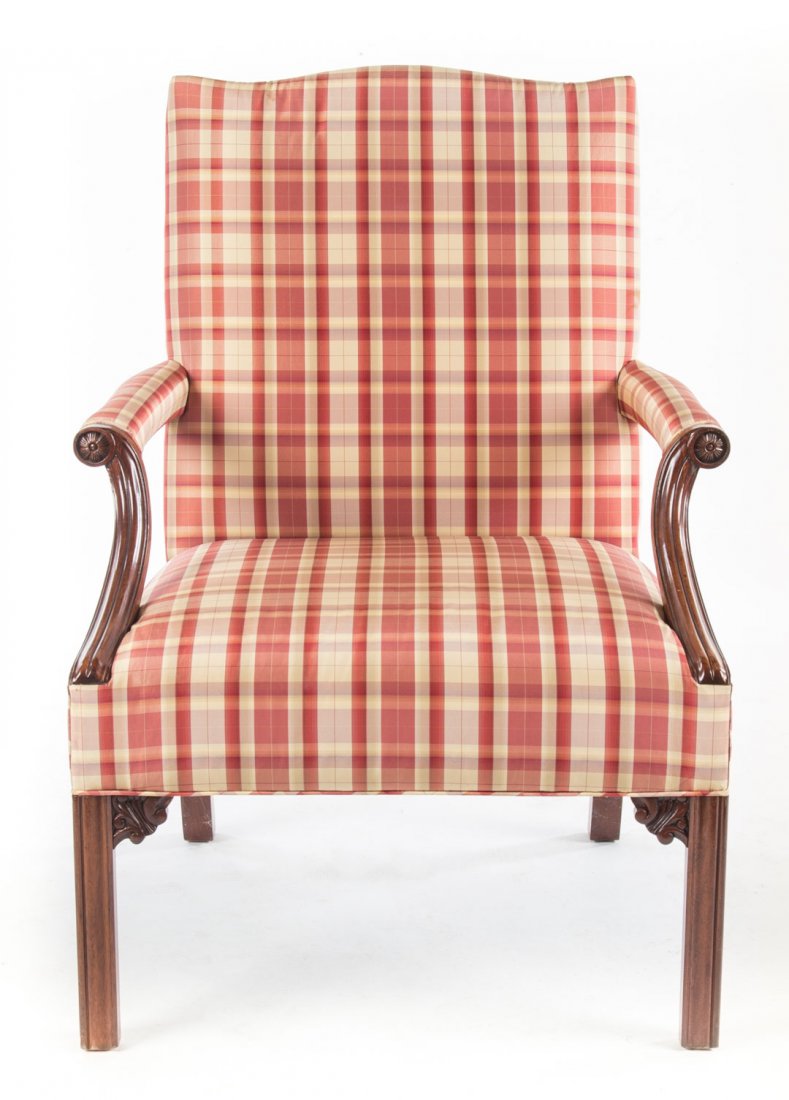 Chippendale style upholstered Raeburn chair: upholstered back, arms and seat over frame, exposed carved mahogany arms with rosette terminals, straight molded legs with foliated spandrels, 40 in. H., 37 in. W., 25 in. D.