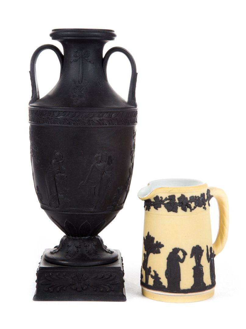 Wedgwood black basalt urn and jasperware jug: 20th century; double-handled urn on pedestal with classical figure relief decoration, 9 in. H., and jug with beige ground and black relief figures, 4 in. H.