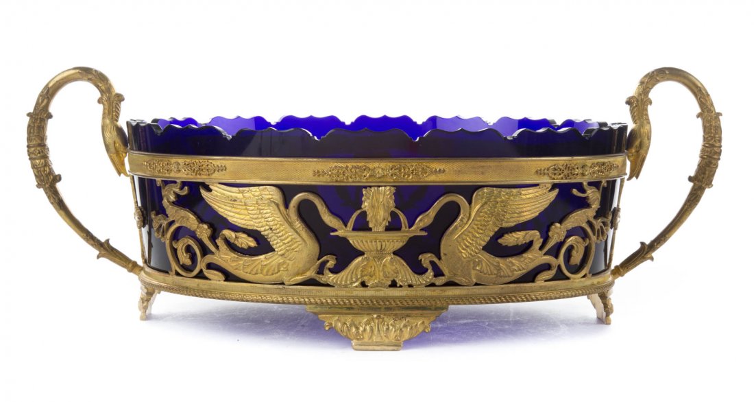 French Empire style gilt metal & glass centerpiece: 20th century; gilt metal base with swan-form handles and similar reticulated relief decoration with removable scalloped cobalt glass liner, 7 in. H., 19 in. W.