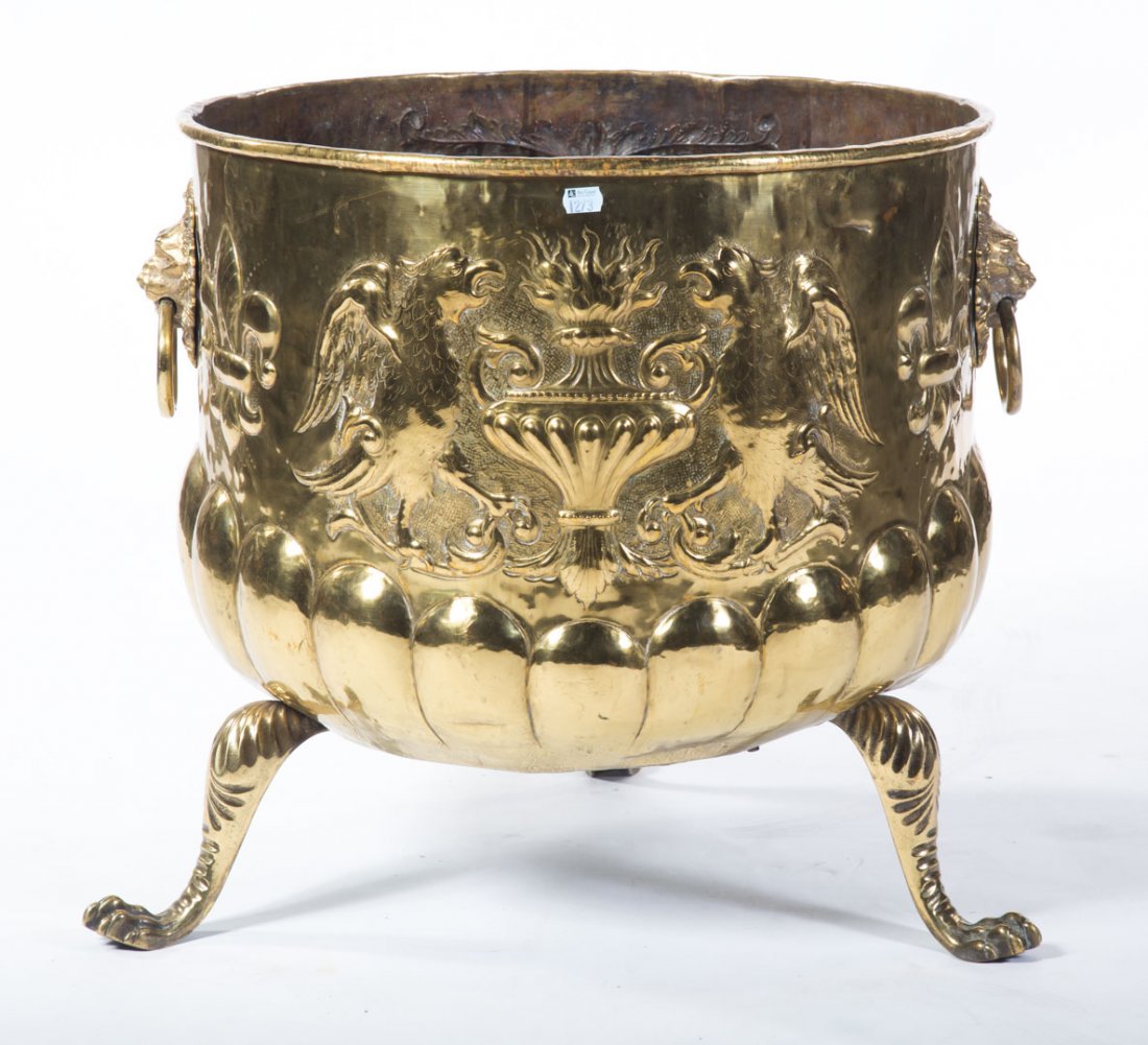 Baroque style brass jardinere: relief of lions and lion mask handles, with paw feet, 20 in. H., 22 1/2 in. Diam.