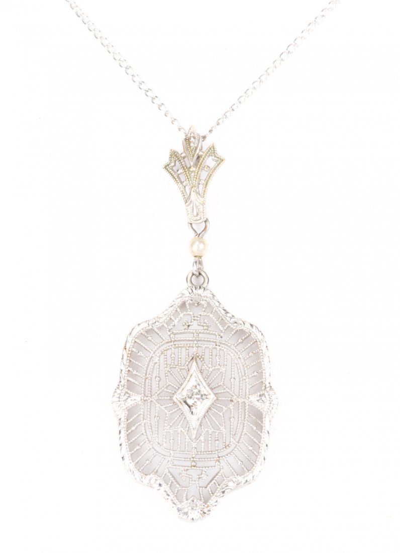 An Edwardian Filigree and Diamond Pendant: Circa 1900's 14K white gold open filigree pendant with 1 full cut diamond set in the center, 18 in. fine cable link chain, 2 grams tw
