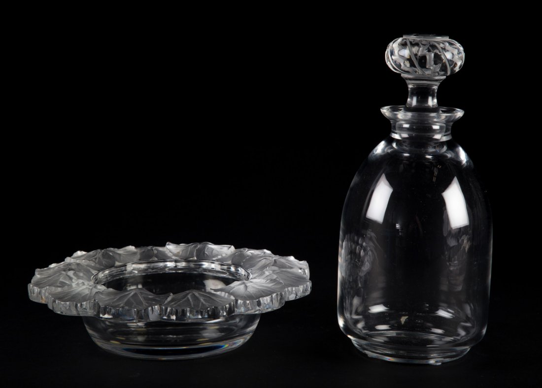 Lalique crystal decanter and bottle coaster: decanter in the Saint Hubert pattern, 10 in. H., and wine bottle coaster in the Honfleur pattern, 8 1/2 in. Diam., both inscribed "Lalique, France"
