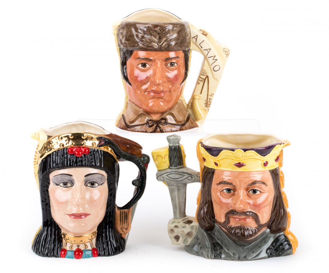 Three Royal Doulton double side character jugs: including: "King Arthur & Guinevere," D 6836, "Antony & Cleopatra," D 6278 and "Battle of the Alamo 1836..." D 6729, 6 1/2 to 7 1/4 in. H.