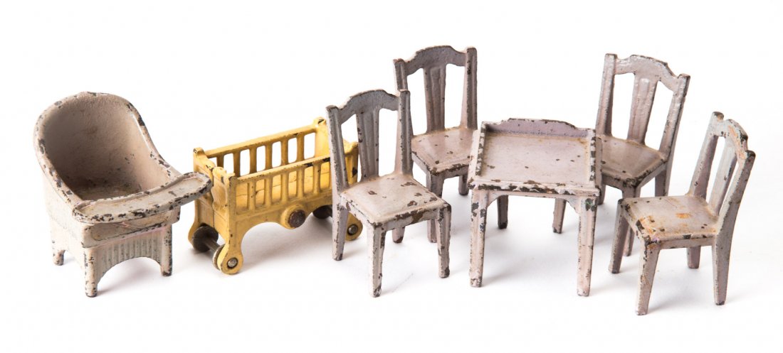 Seven pieces of painted metal doll house furniture: circa 1930s; either Kilgore or Hubley, including: four dining side chairs, writing table, potty chair and crib