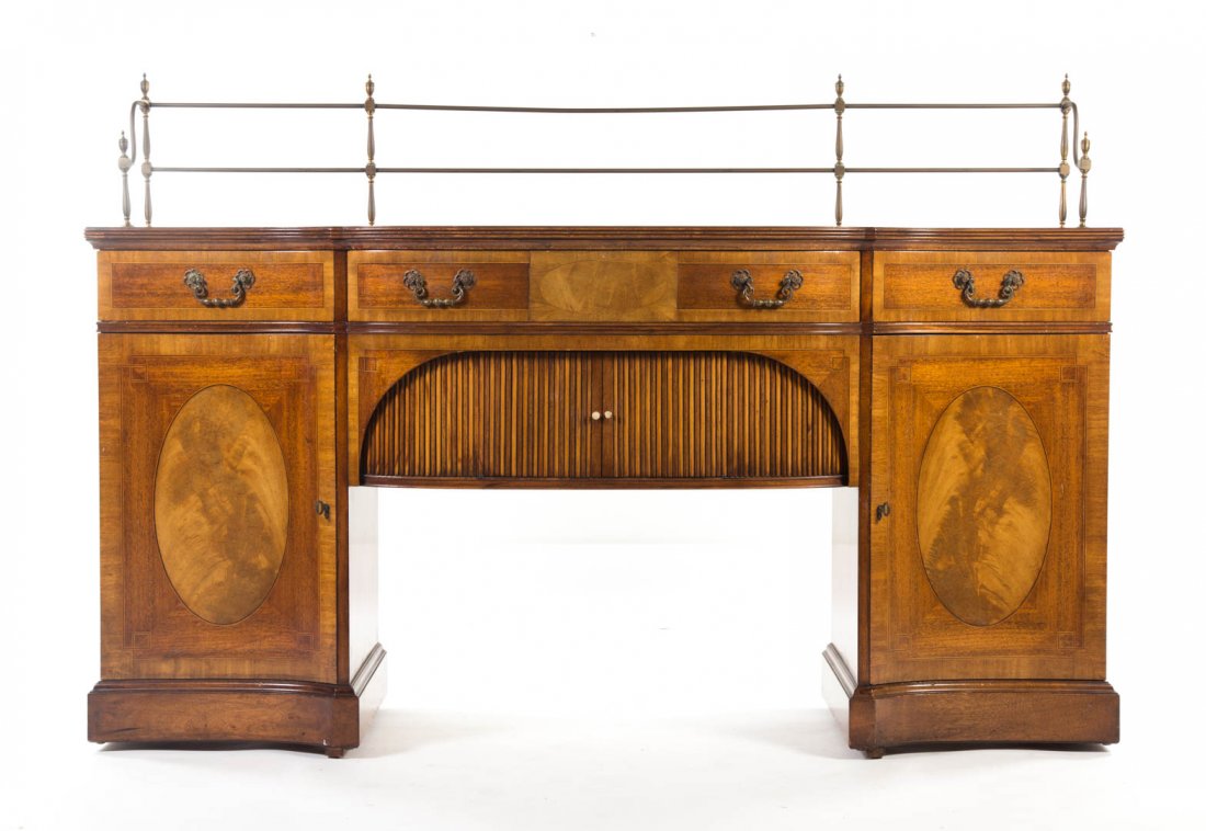 George III style inlaid mahogany sideboard: Grosfeld House, mid-20th century; serpentine front, reeded edge, brass gallery, bowed center drawer over compartment beneath enclosed by tambour doors, convex side drawers with compartments beneath en