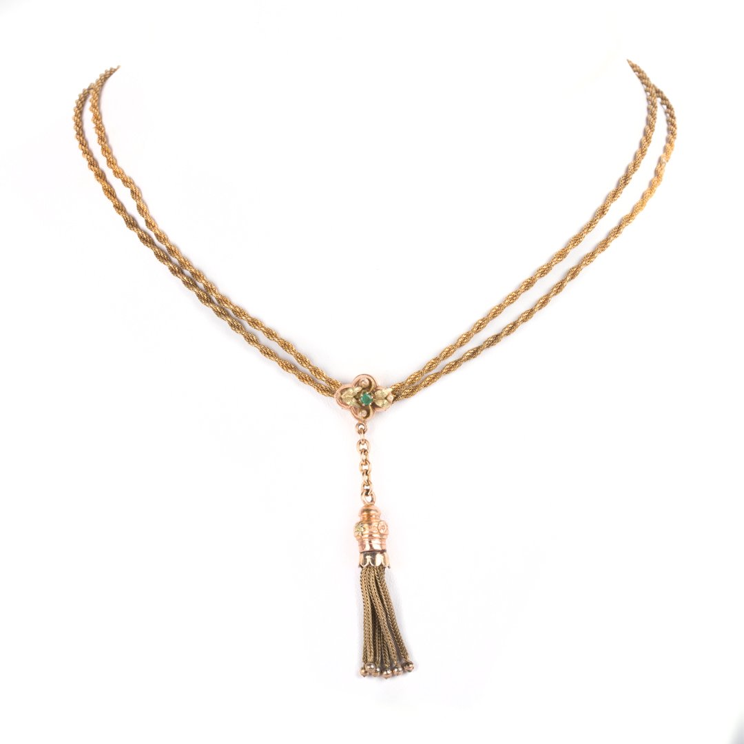 A Victorian Slider Chain with Tassel: 14K yellow gold rope chain, with slider, faceted emerald embellishment with tassel, 64 in. L., 21 grams tw