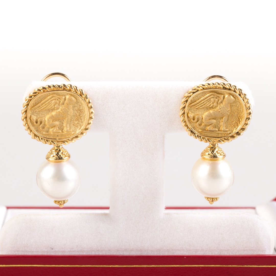 A Pair of 18K Intaglio South Sea Pearl Earrings: 18K yellow gold earrings featuring oval gold intaglio of Griffin with rope edge and granulating accents, South Sea pearl at bottom of intaglio, measure 12mm, very high luster, slight rose overtone, 1.