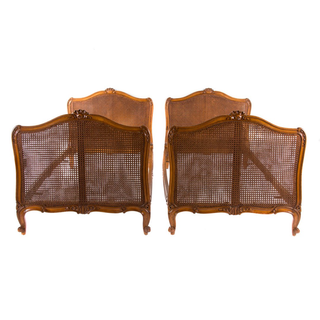 Pair Louis XV style caned daybeds: early 20th century; serpentine crest rail with shell carved motif, cabriole legs, carved bed rails, 37 7/8 in. H., 39 1/4 in. W.,