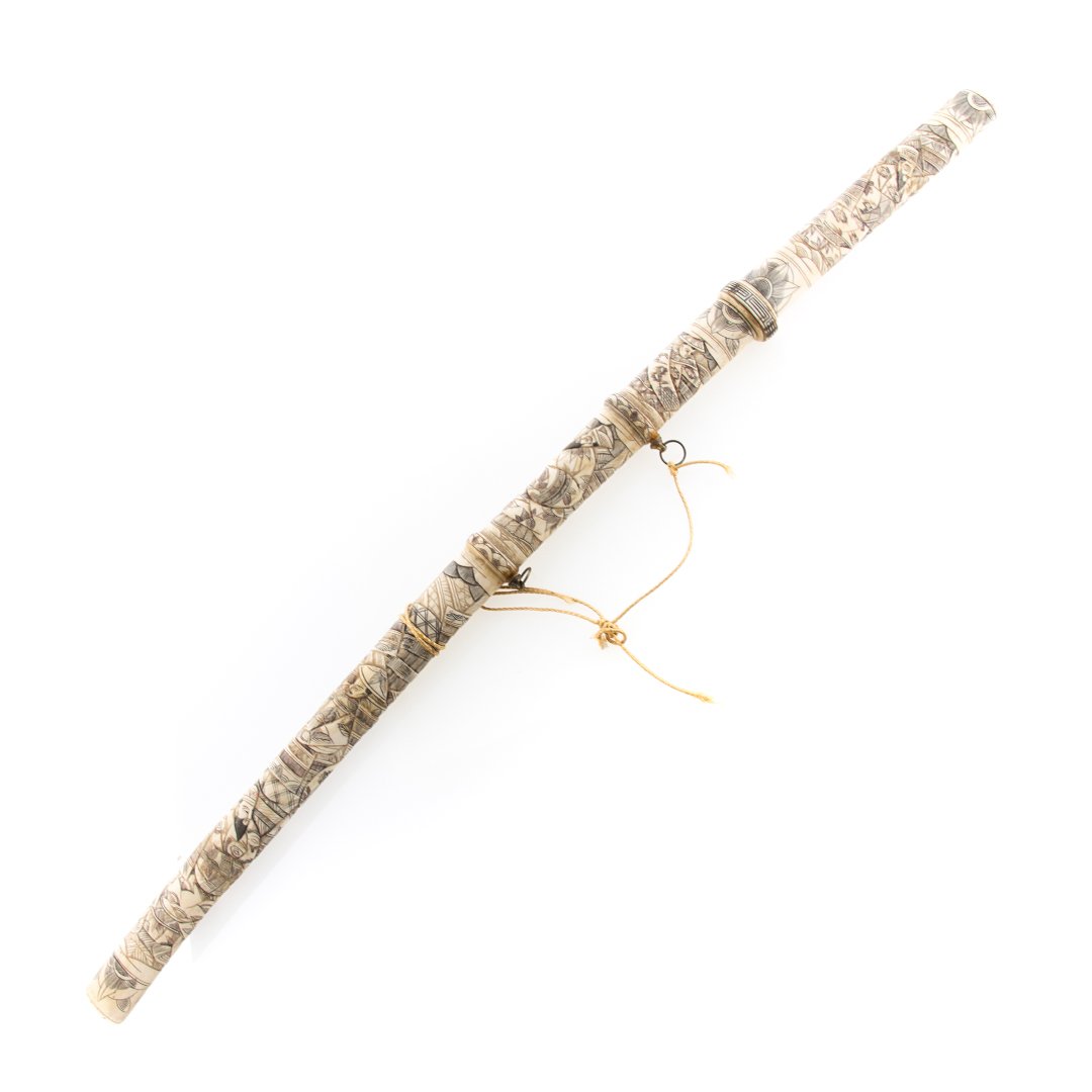 Japanese carved bone sword sheath and handle: early 20th century; handle and sheath with elaborately and ink highlighted figural relief decoration, with metal blade, 33 in. L. total, blade - 19 1/2 in. L.
