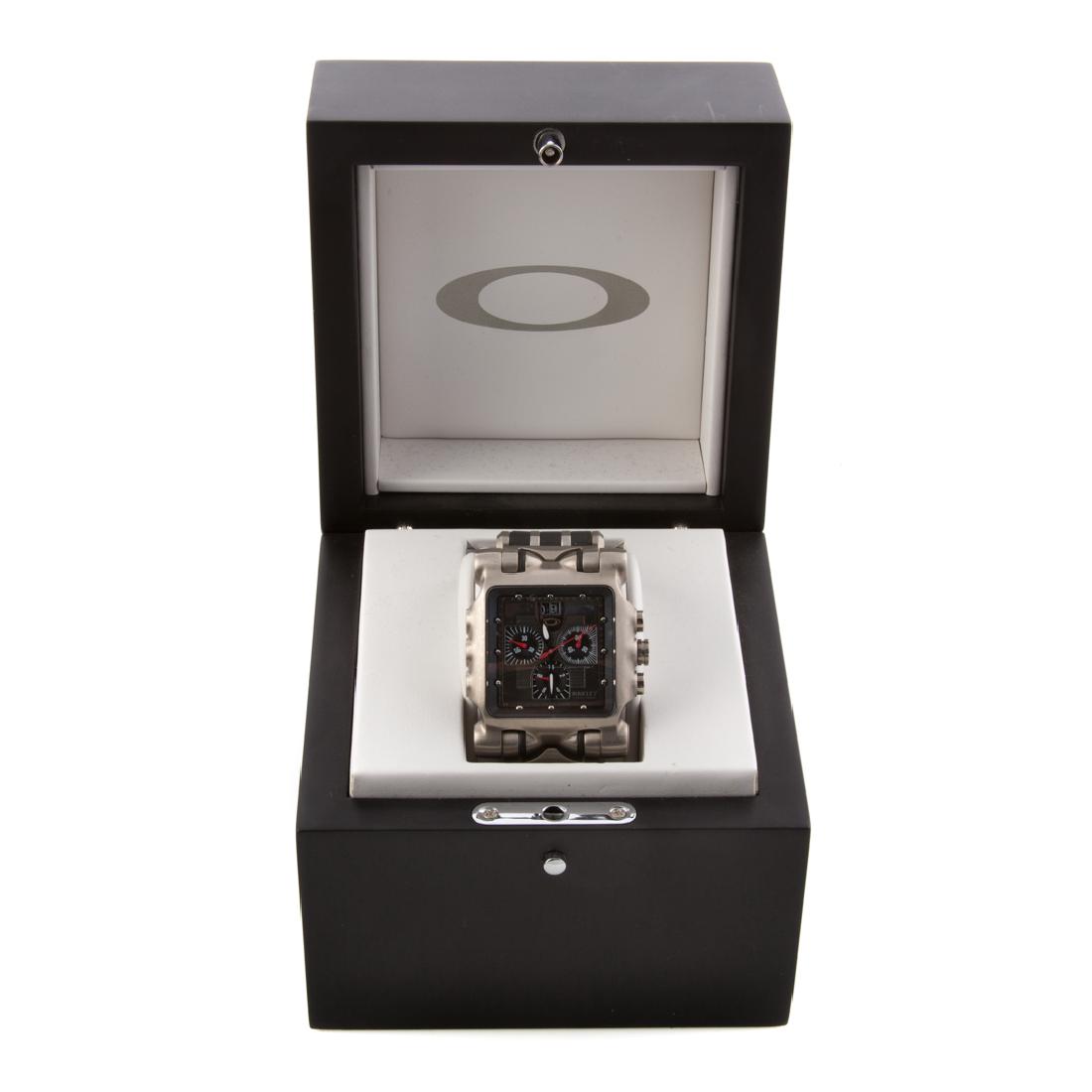 A Gentlemen's Oakley Titanium Watch: Swiss made, sapphire crystal, water resistant, black rubber strap, original box