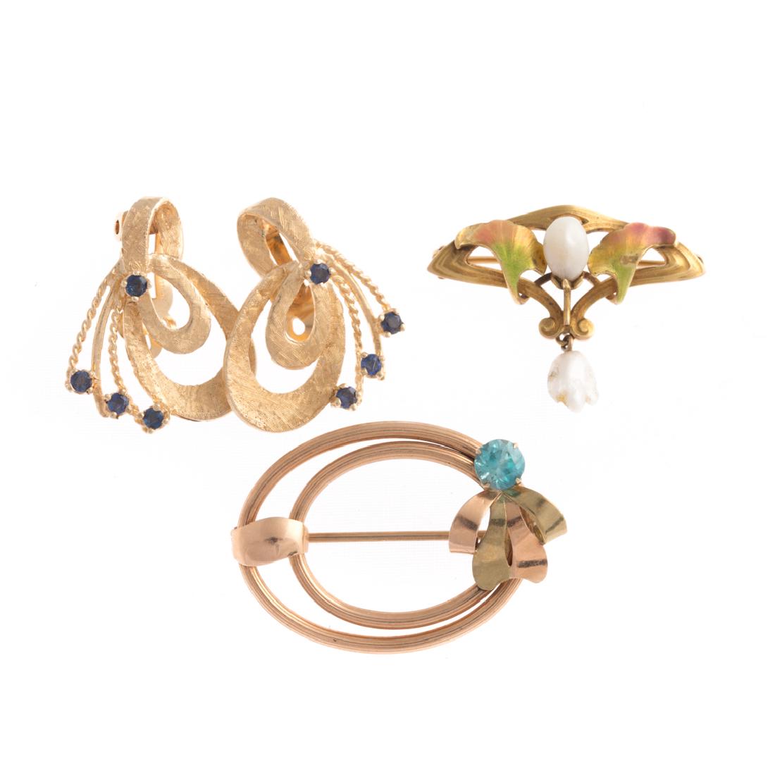 A Selection of Vintage Gold Jewelry: 1) 14K yellow gold clip earrings with small faceted round sapphires, 2) 14K yellow gold enamel and freshwater pearl pin, and 3) 10K yellow gold oval pin with a round blue zircon, 13 grams tw