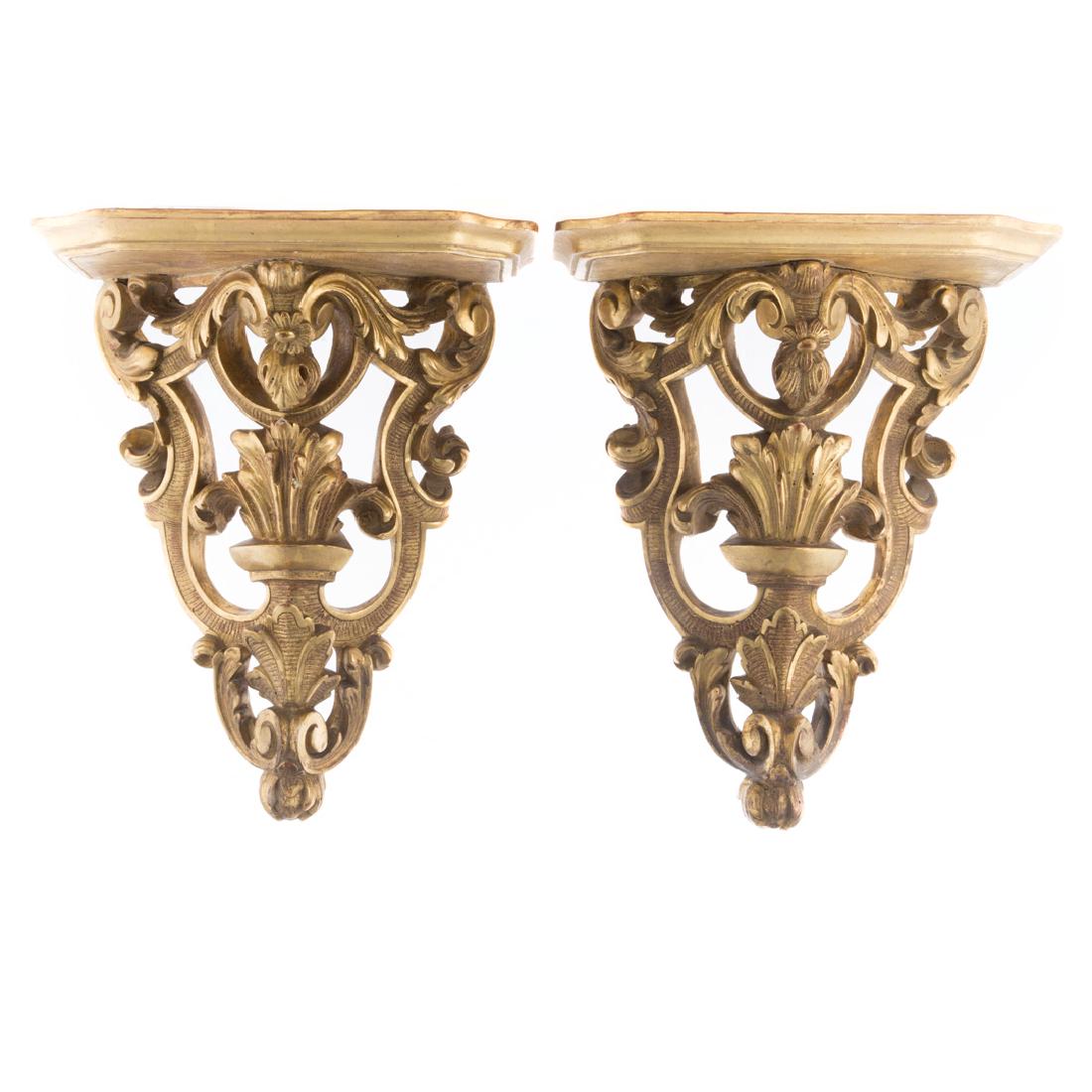 Pair of George III style giltwood wall brackets: 20th century; each with a shelf and scroll and foliate carved giltwood supports, 17 in. H., 14 in. W., 8 1/2 in. D.