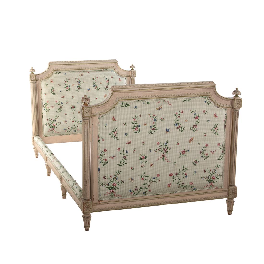 Louis XVI style painted day bed: early 20th century; upholstered head and foot board with carved crest rail, flanked by tapered fluted columns with foliate finials, round tapered feet, with matching side rails, 36 in. H., 42 in. W., 