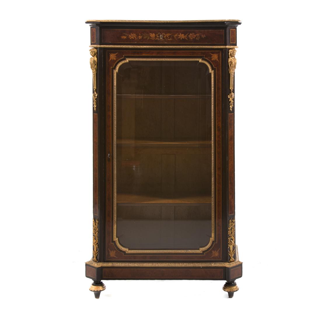 Napoleon III dore bronze mounted bibliotheque: mid 19th century; floral inlay, burl walnut and ebonized wood, flat canted corner top, frieze drawer, compartment with shelving enclosed by beveled glass door, round tapered feet, 52 1/2 in. H., 28 1/