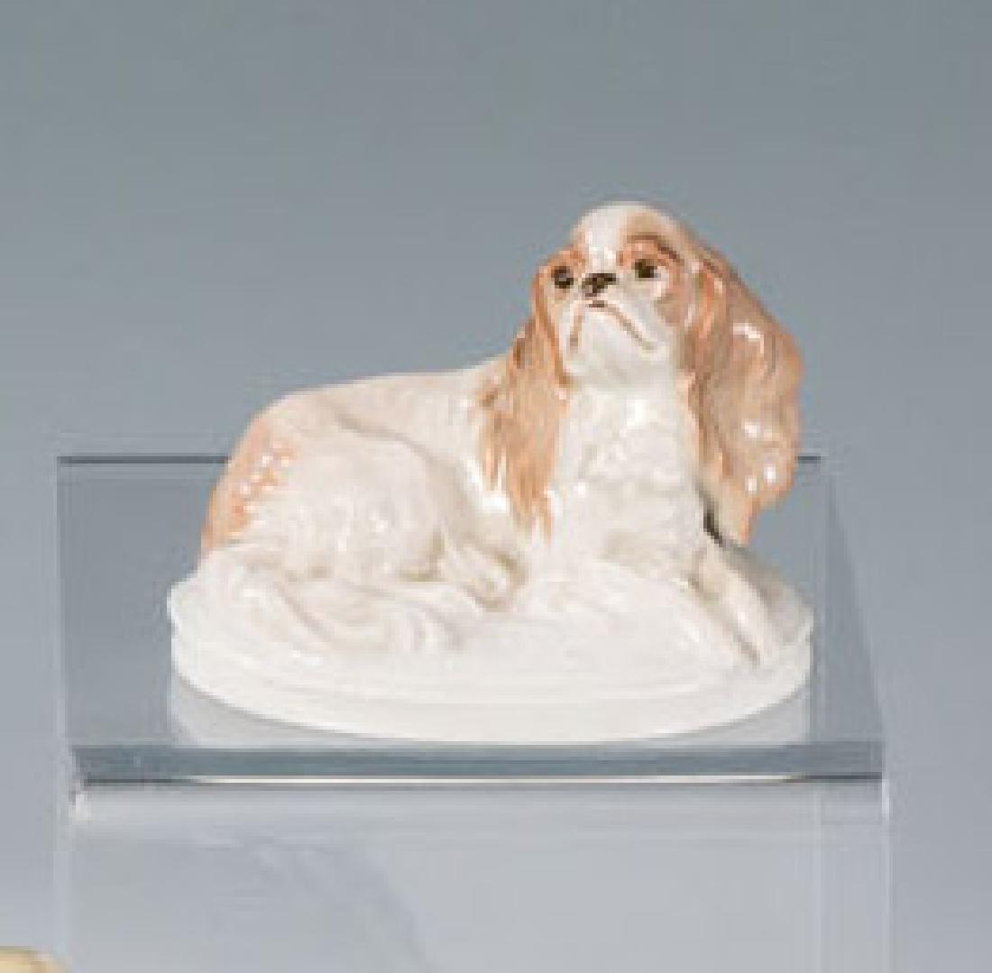 King - Charles - Hund: King - Charles - Hund Fritz Diller (Entwurf), Rosenthal, 1913 Auf Ovalsockel liegend. Sparsame Unterglasurbemalung. Unterglasurgrüner Manufakturstempel, K.287 (eingestempelt). H. 6,5 cm E. Niecol, Ro
