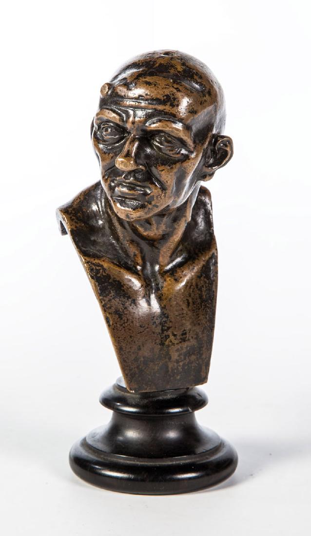 Porträtbüste im Stil von Franz Xaver Messerschmidt: Porträtbüste im Stil von Franz Xaver Messerschmidt 19./20. Jahrhundert Ausdrucksstarker Charakterkopf eines glatzköpfigen Mannes. Bronze patiniert auf profiliertem Holzsockel. H. 14 cm (inklusive S
