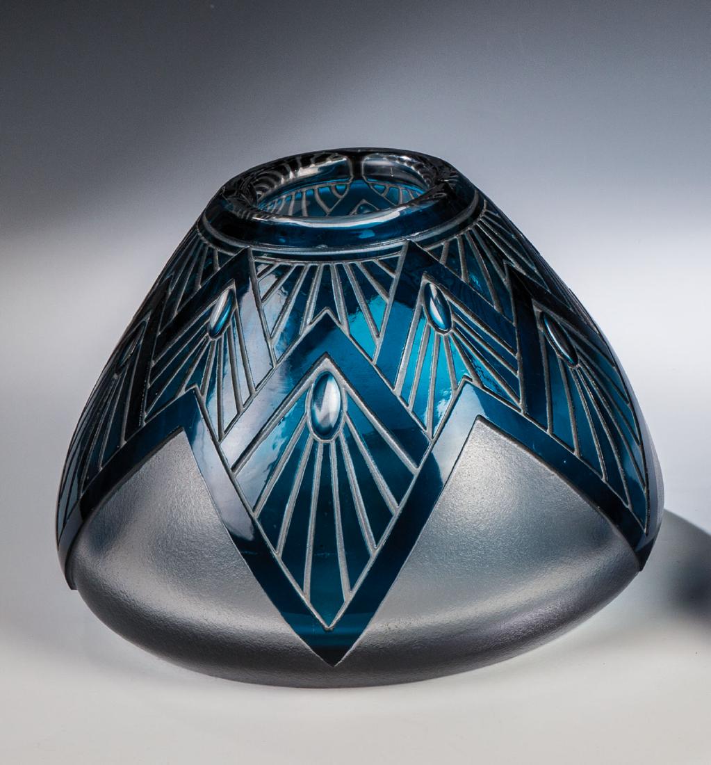 Vase: Vase Cristalleries de St. Louis, um 1930 Dickwandiges, farbloses Glas, blau überfangen. Umlaufend tief geätzter Strahlendekor mit tief geschliffenen Oliven. Unterseite mit rautenförmige