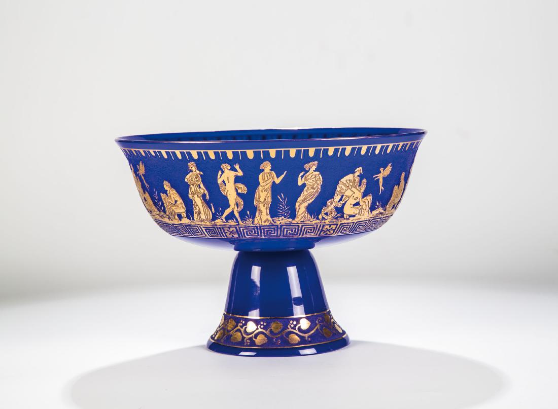 Fußschale ''Etrusk'': Fußschale ''Etrusk'' Loetz Wwe., Klostermühle, 1928 Farbloses, kobaltblau unterfangene Glas. Umlaufend vierfach wiederholter antikisierender Figurenfries in vergoldeter Reliefätzung, da