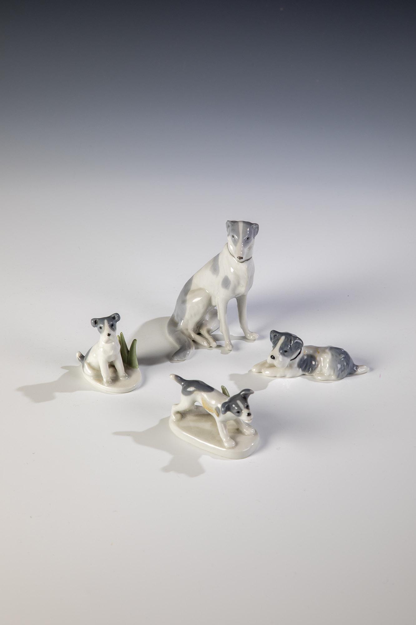 Vier Hundefiguren: Vier Hundefiguren u. a. GebrÃ¼der Metzler & Ortloff, 20. Jh. Naturalistische Unterglasurmalerei. Manufakturmarken und diverse Modellnummern. Eine Hundefigur an der Rute min. best.. H. 3 - 8,5 cm