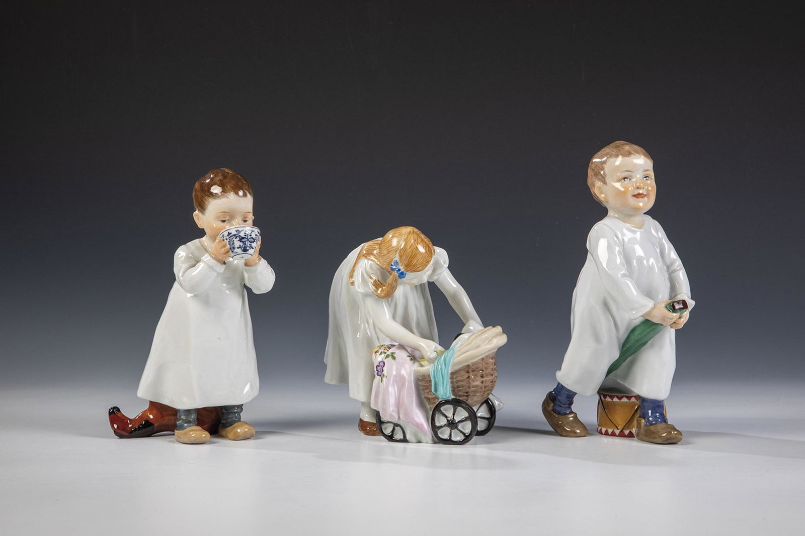 Kind: Kind Konrad Hentschel (Entwurf) 1905, Meissen (AusfÃ¼hrung), vor 1924 Aus einer Zwiebelmustertasse trinkend. Staffiert in polychromer Aufglasurbemalung. Holzpferdchen min. rest.. Blaue Schwertermark