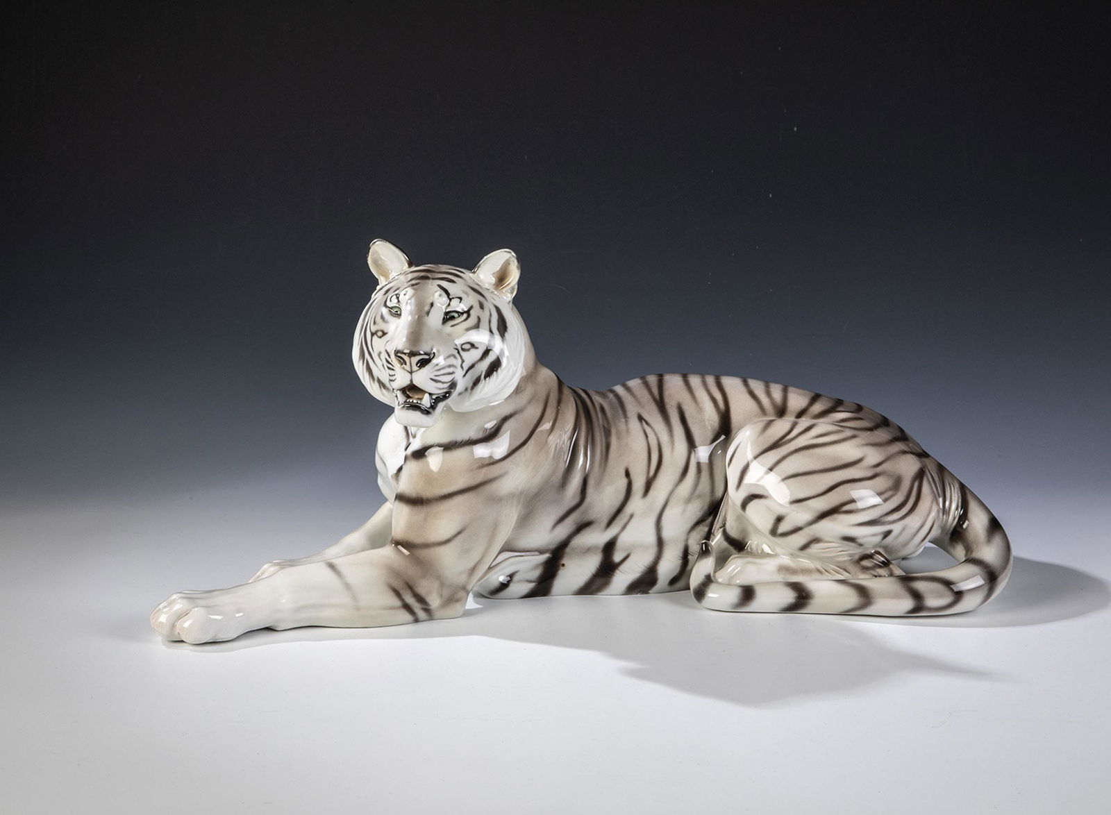 Tiger: Tiger Theodor KÃ¤rner (Entwurf), Rosenthal, um 1927 Liegend, Kopf leicht nach links gewendet. Staffiert in naturalistischer Unterglasurbemalung. Unterseite bez.: unterglasurgrÃ¼ner Manufakturstemp