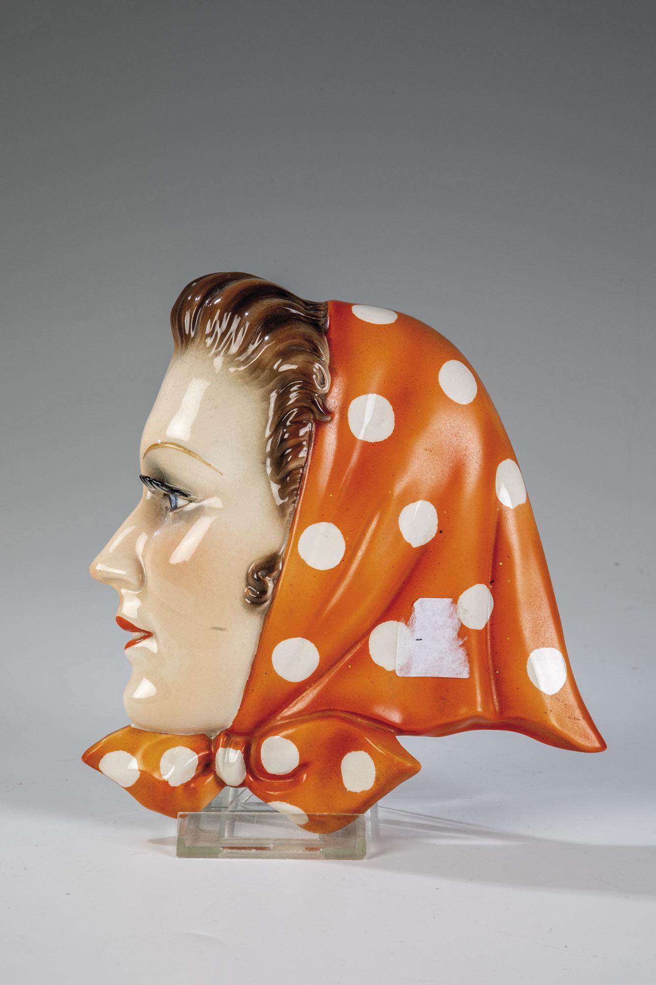 Wandmaske ''MÃ¤dchen mit Kopftuch'': Wandmaske "MÃ¤dchen mit Kopftuch" Wilhelm Goebel, Oeslau/Oberfranken, um 1925/30 Feinsteingut. Staffiert in bunten Auf- und Unterglasurfarben. Eingestempelte Manufakturmarke, FX.145. H. 17,5 cm