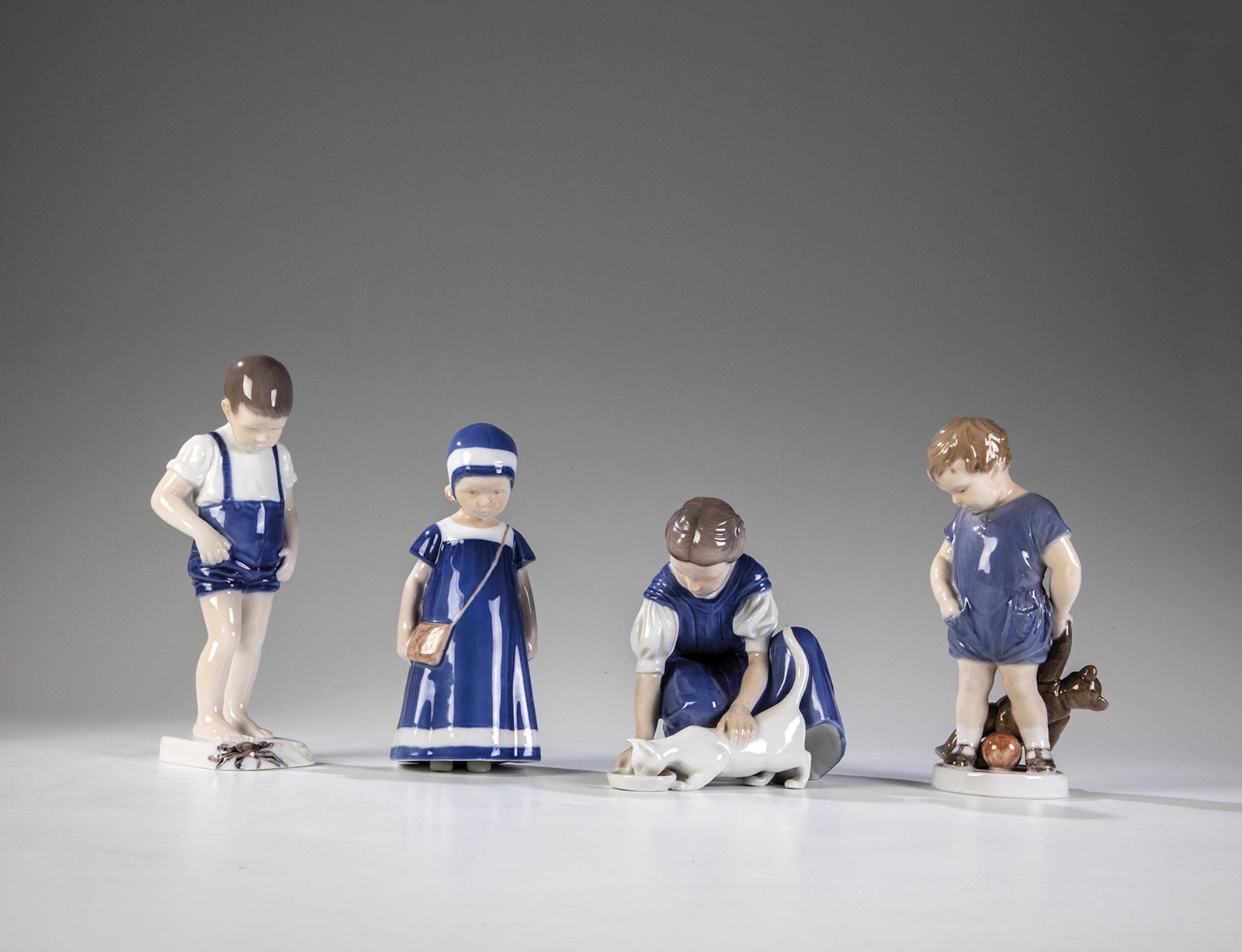 Vierteiliges Konvolut: Vierteiliges Konvolut Bing & GrÃ¸ndahl und Royal Copenhagen, 1915 - 1951 MÃ¤dchen Katze fÃ¼tternd, Knabe mit TeddybÃ¤r und Ball, Knabe mit Krebs, MÃ¤dchen mit Haube. Unterglasurbemalung. Soc