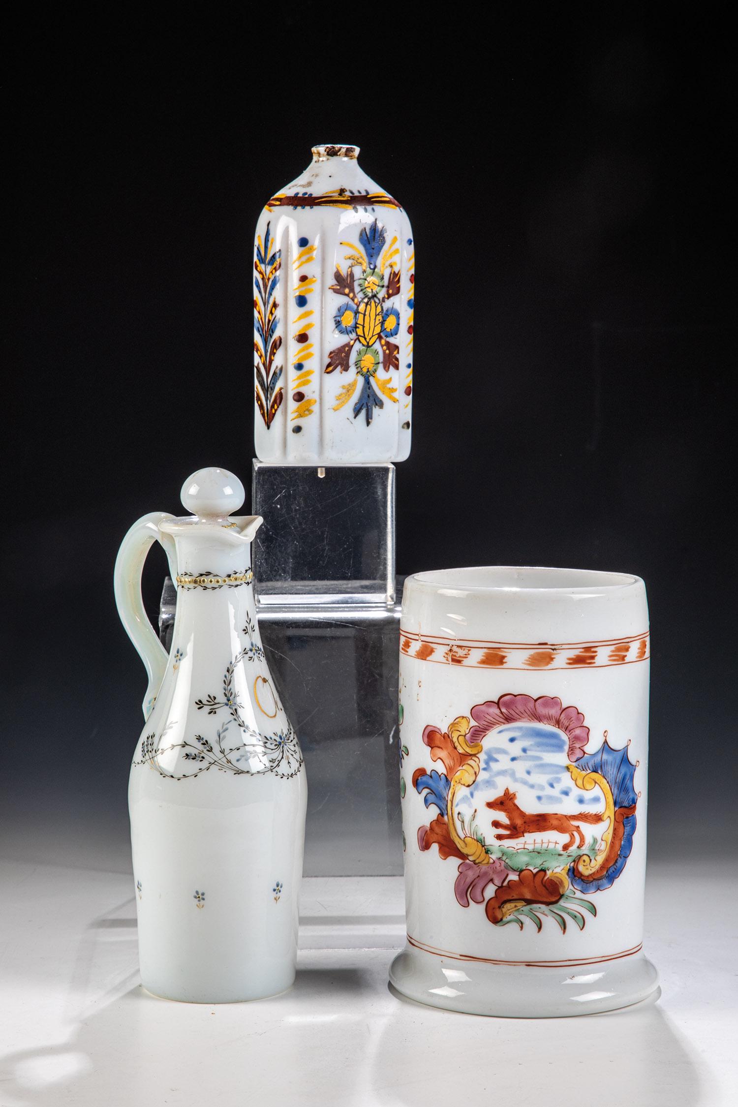 Walzenkrug, Schnapsflasche und Kännchen: Walzenkrug, Schnapsflasche und Kännchen 18./A. 19. Jh. Abrissgläser aus Milchglas. Walzenkrug aus Thüringen und Schnapsflasche polychrom bemalt mit Fuchs in ornamentaler Kartusche bzw. 