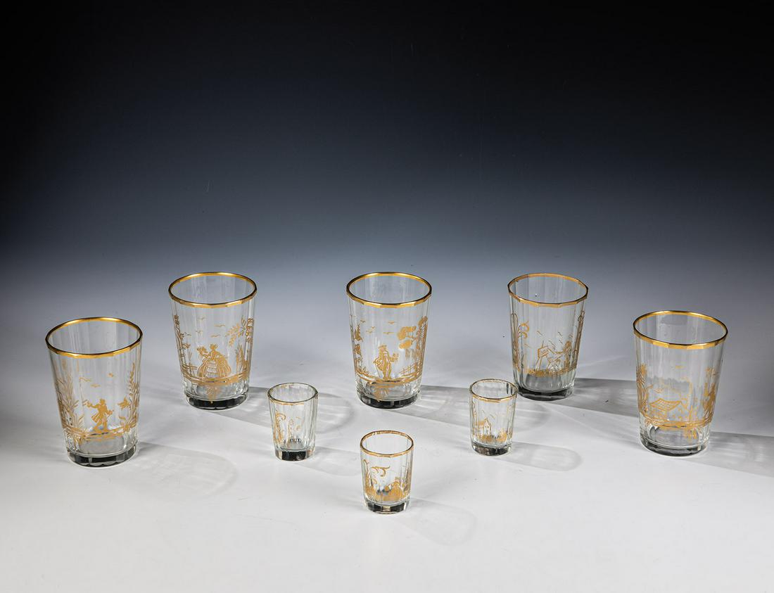 Acht Becher mit Goldmalerei: Acht Becher mit Goldmalerei Böhmen oder Frankreich, 19. Jh. Vielfach facettiertes Glas mit Dekor in Goldmalerei: je eine Rokoko-Figur in Landschaft mit Vegetation, teils mit Architektur. H. 4,5-9