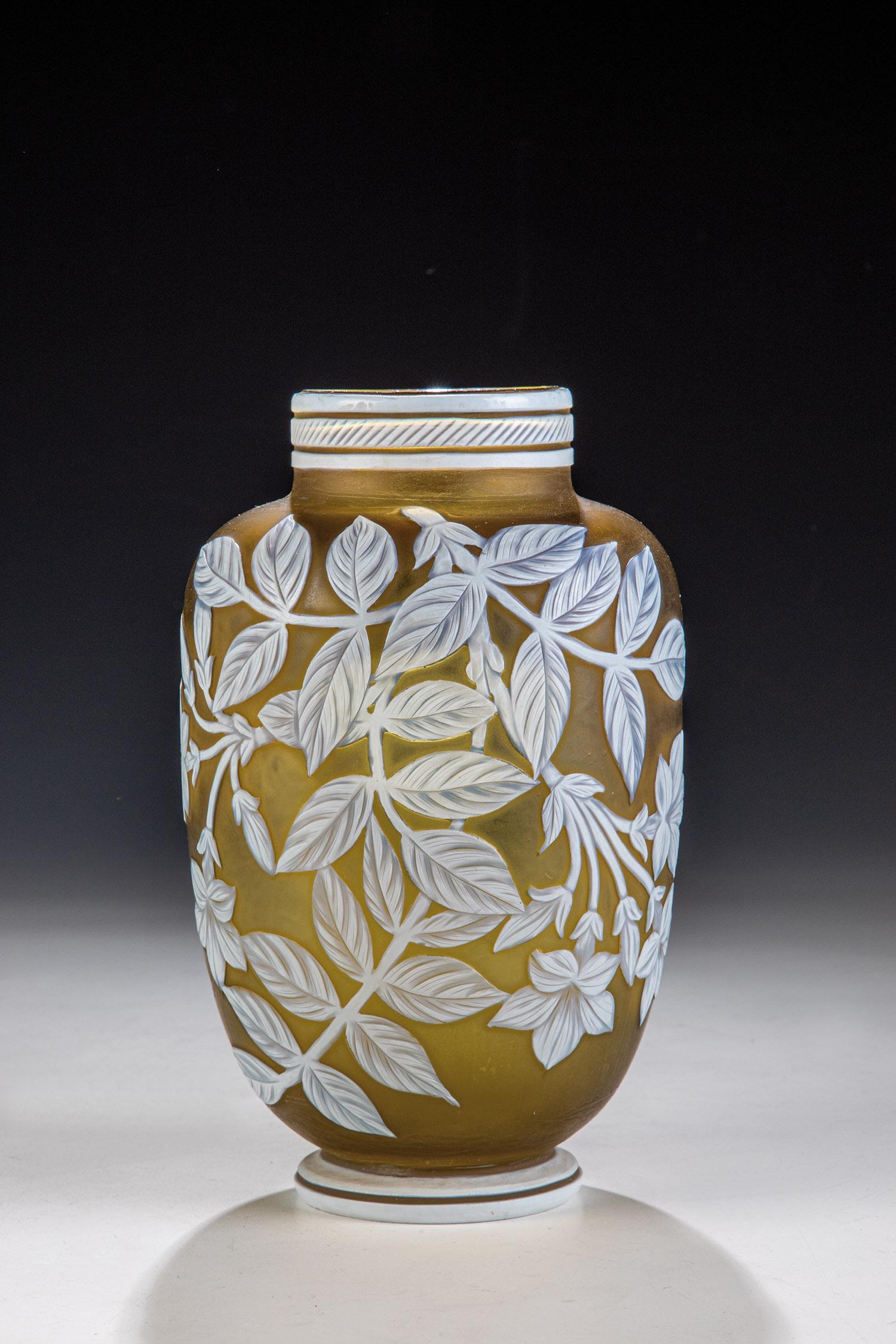 Vase mit Blütenzweigen: Vase mit Blütenzweigen England, wohl Thomas Webb, 2. H. 19. Jh. Gelbgrünes, weiß überfangenes Glas mit durschliffenen Ornamenten: Blatt- und Blütenzweige. H. 15 cm.