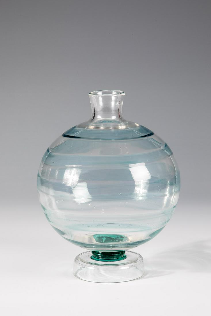 Seltene Kugelvase ''a fili'': Seltene Kugelvase ''a fili'' Carlo Scarpa (Entwurf), Compagnia Venezia Murano, C.V.M., um 1930 Farbloses, dünnwandiges Glas mit hellblauer Fadenaufschmelzung, dunkelgrüner Nodus, angesetzter Fuß. B