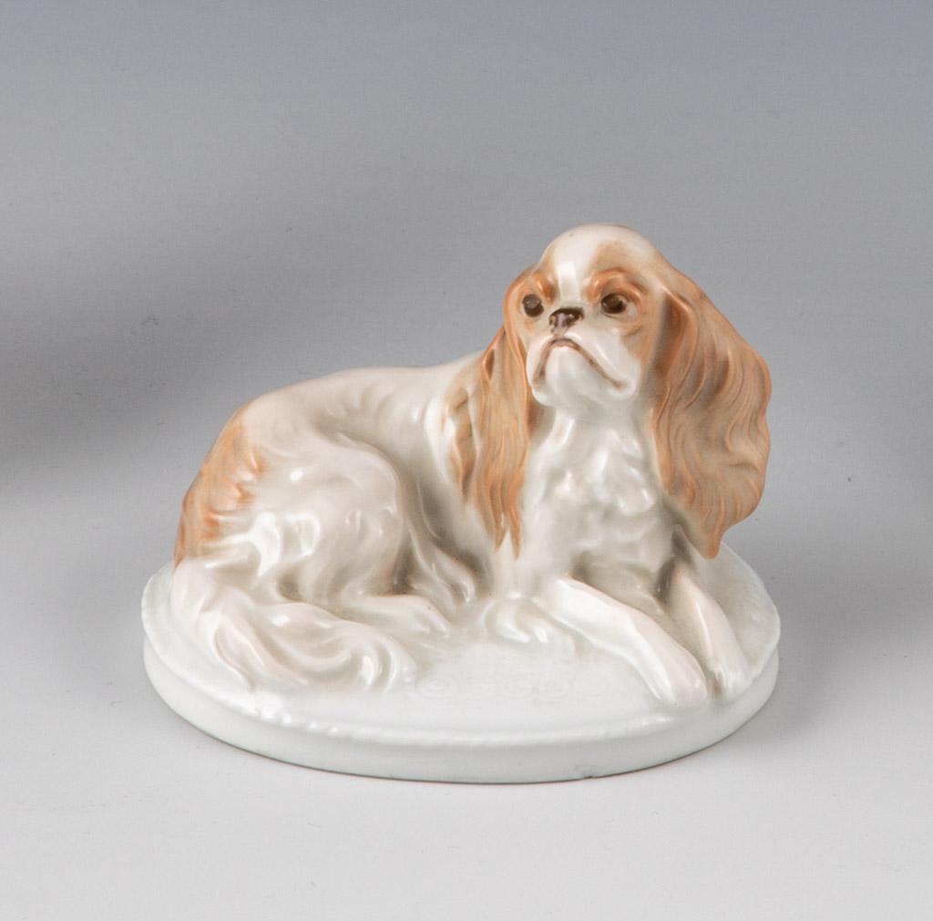 Sitzender King Charles Spaniel: Sitzender King Charles Spaniel Fritz Diller (Entwurf), Rosenthal, 1913 Auf ovalem Sockel. Staffiert in naturalistischer Unterglasurbemalung. Bez.: Unterglasurgrüner Manufakturstempel, K.287. L. 8 cm.