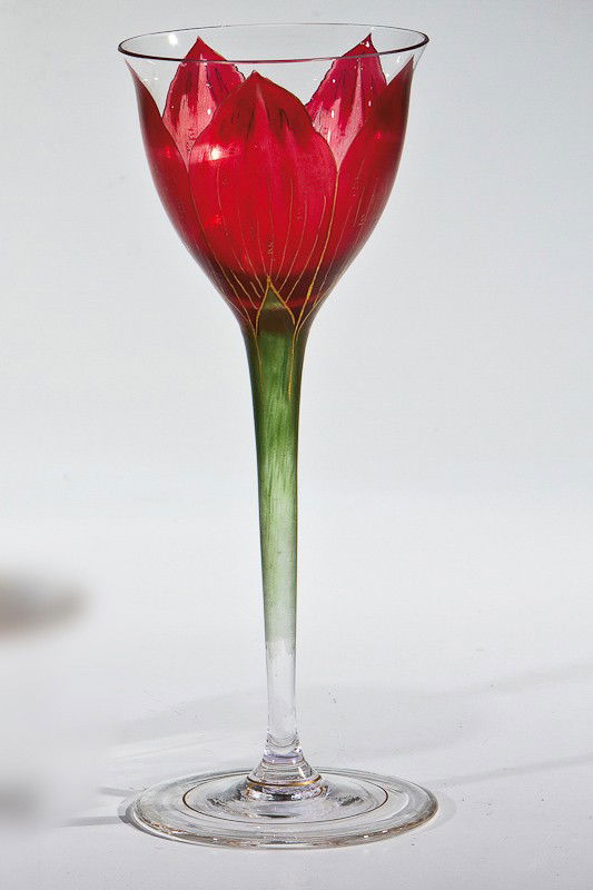 Stängelglas Fritz Heckert, Petersdorf, um 1900 Far: Stängelglas Fritz Heckert, Petersdorf, um 1900 Farbloses Glas mit goldkonturiertem Transparentemaildekor in Grün und Pink: stilisierte Tulpenblüte. H. 20,5 cm Lit.: U. Schröder: Trinkgläser vom J