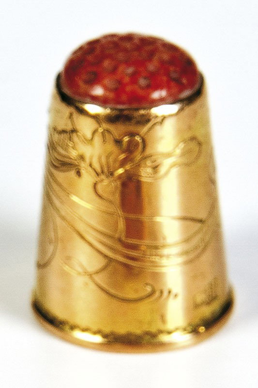 A gold thimble engraved with scrolling foliage. Be: A gold thimble engraved with scrolling foliage. Bearing pseudo Russian hallmarks. 2.2 cm high, 7 gr. Deutsche Beschreibung: Goldener Fingerhut Auf der Wandung floraler Gravurdekor. Gestempelt mit pseu