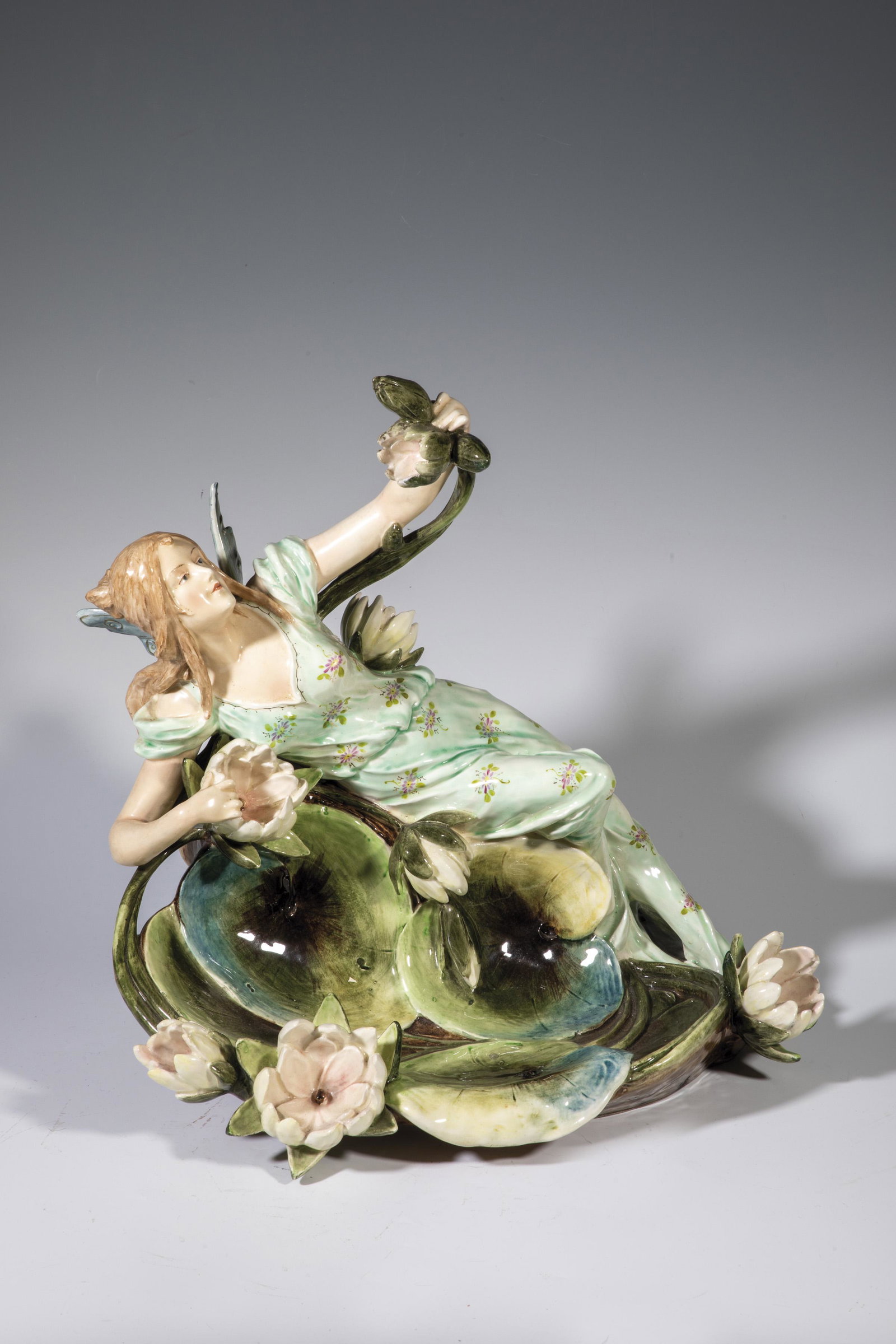 Elf with water lilies: Elfin with water lilies Bohemia, around 1900 Earthenware, colorful underglaze painting with gold staffage. Minor restorations. H. 44 cm; W. 42 cm