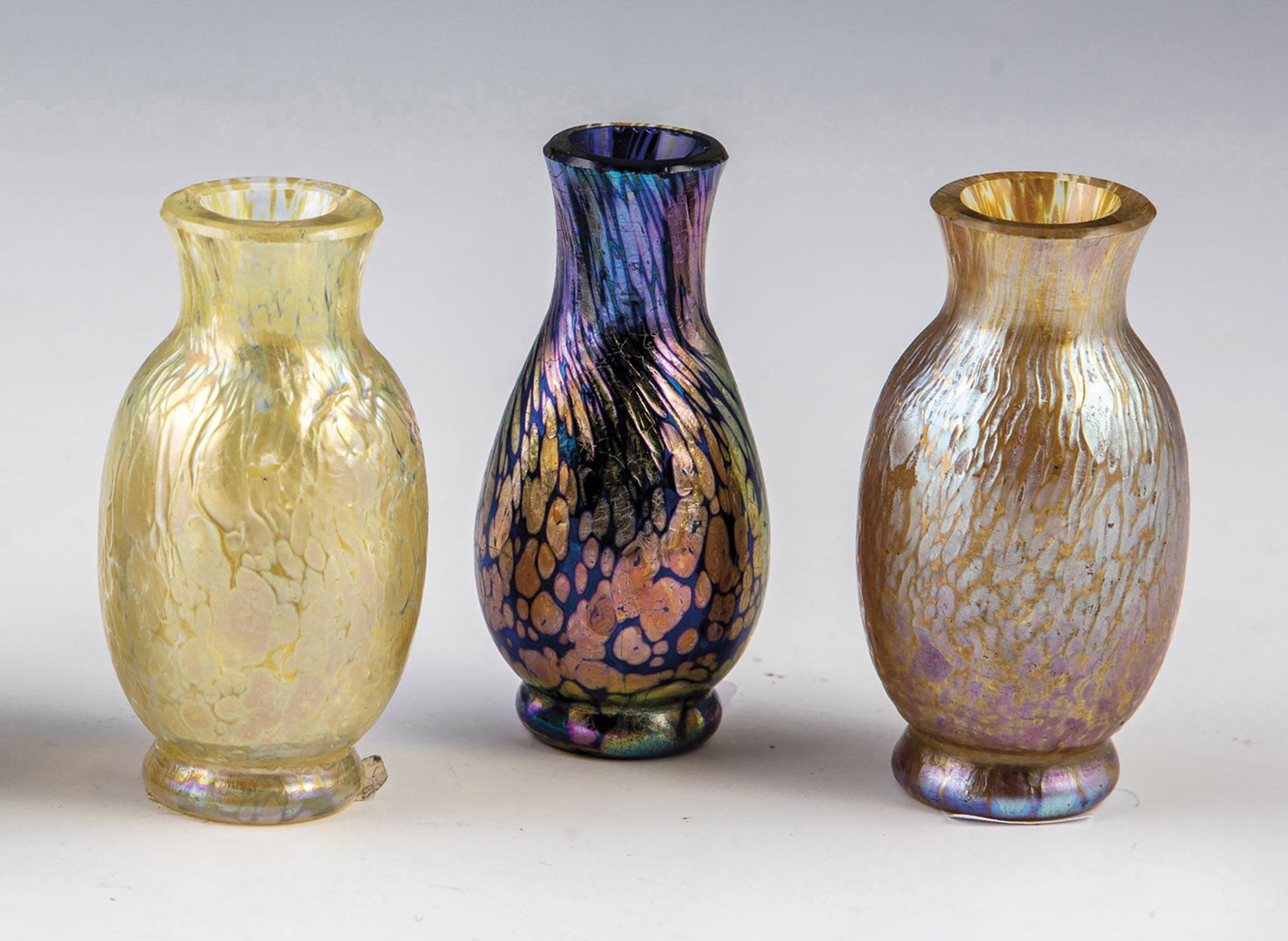 Three miniature vases: Three miniature vases Loetz Wwe., KlostermÃ¼hle, c. 1900 Colorless or cobalt blue glass with silver-yellow crumb fusions. Matt iridescence. H. 5-5,5 cm.
