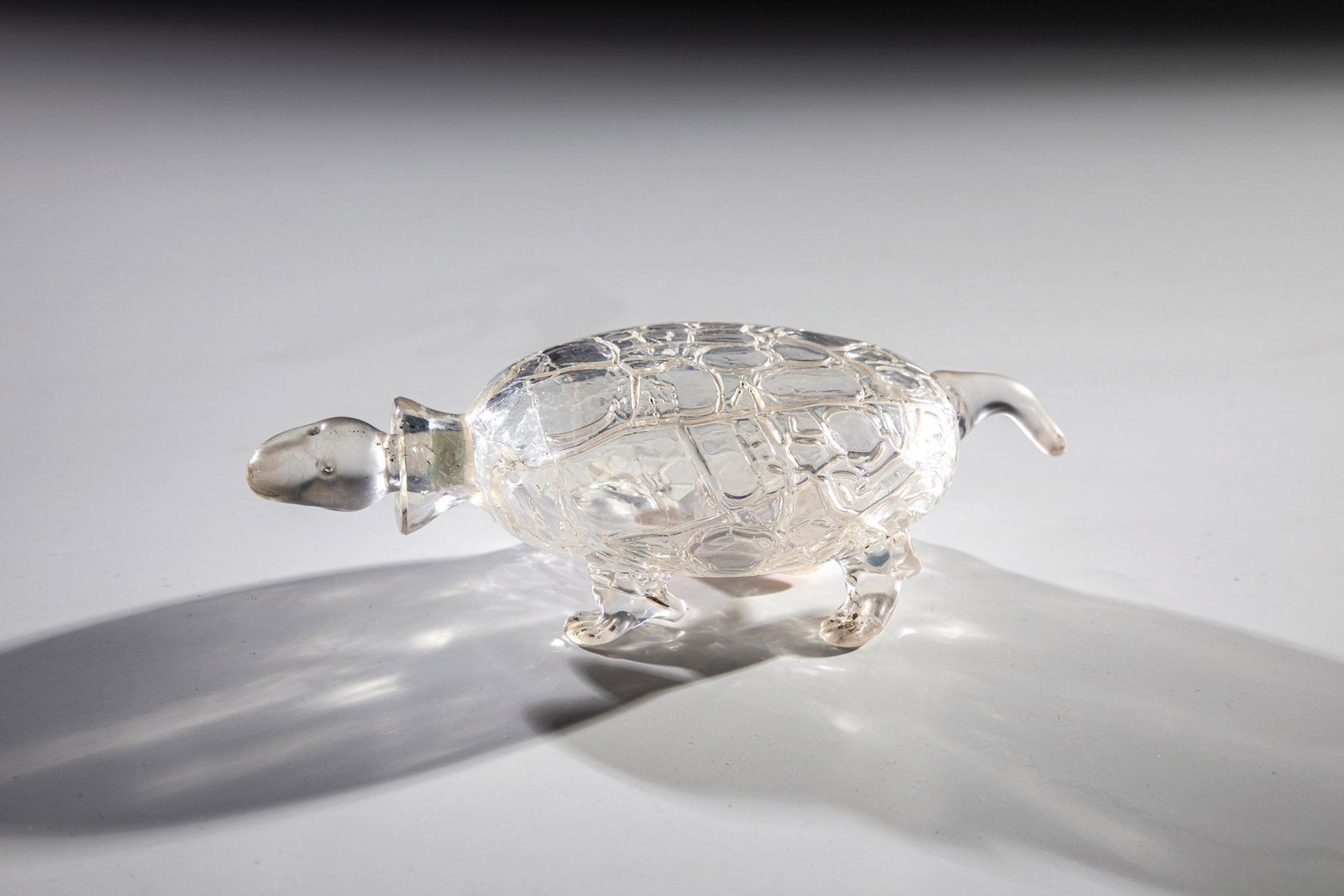 Bottle with stopper in the shape of a turtle: Flacon with stopper in the form of a turtle Loetz Wwe., KlostermÃ¼hle, c. 1920 Colorless glass, partly naturalistically executed, the feet set and pinched, stopper worked as a head. Iridescent. L. 1