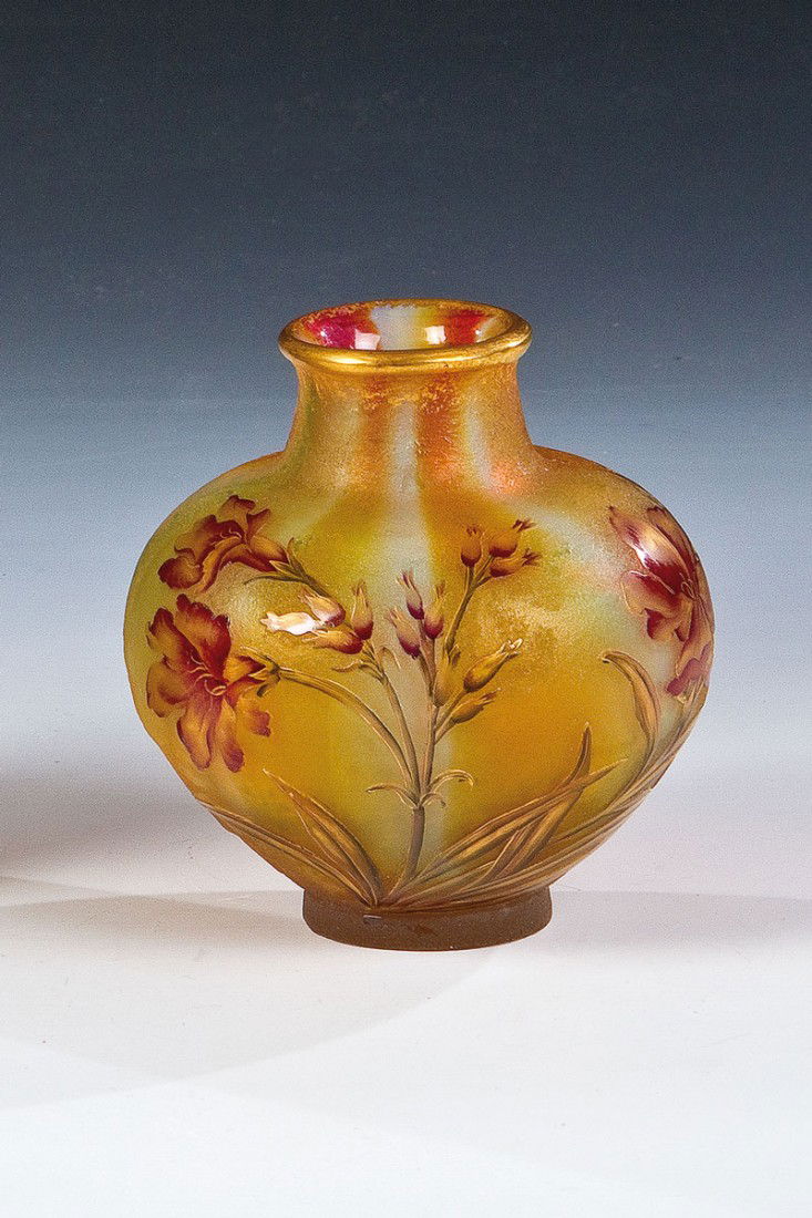 Vase mit Blüten: Vase mit Blüten Daum Frères, Nancy, um 1900 Farbloses Glas mit grün-weiß-orange-rotem, senkrecht gestreiftem Unterfang. Außenwandung eisglasartig geätzt. Glatter Dekor in Rottönen, Dunkelgrün